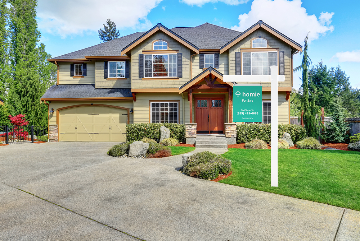 beautiful craftsman home with homie for sale sign in the yard