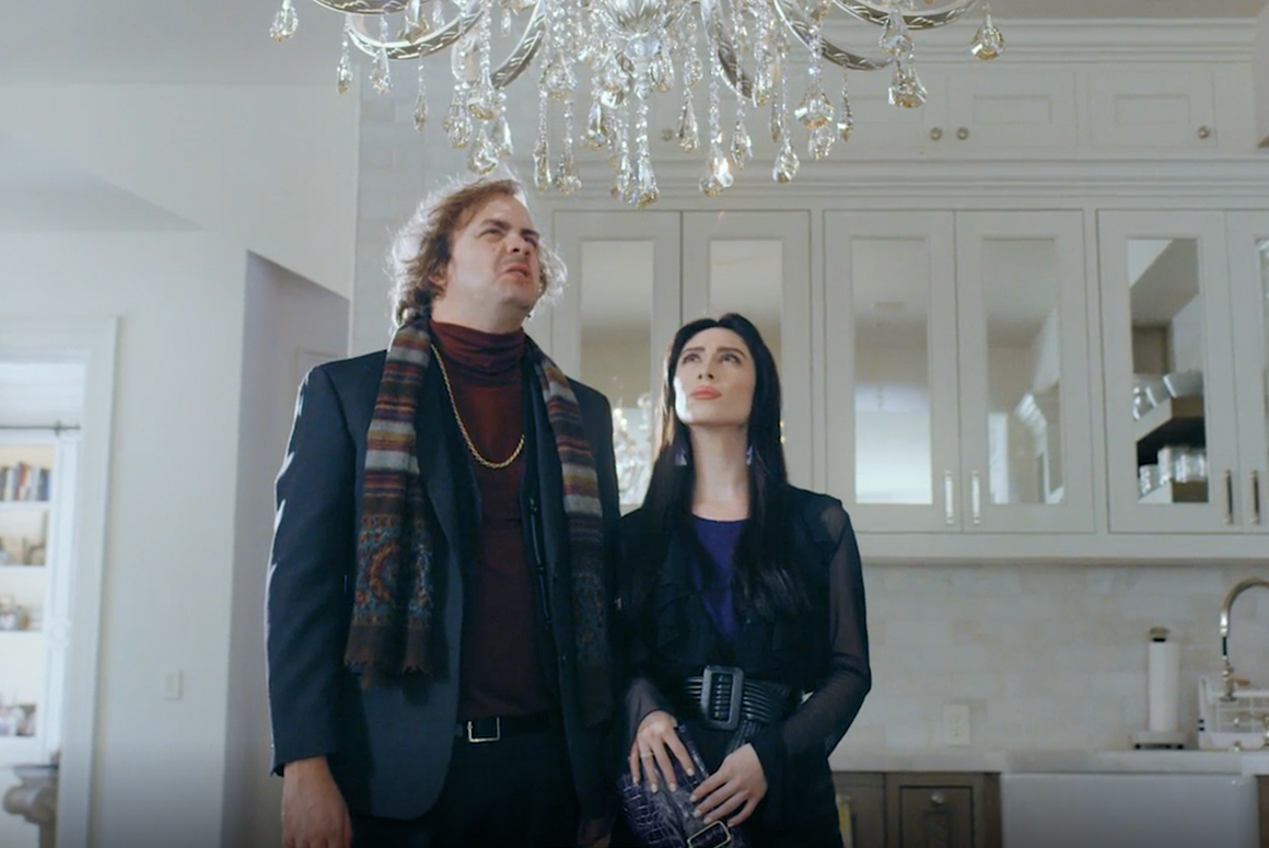 couple looking at a chandelier together, disappointed