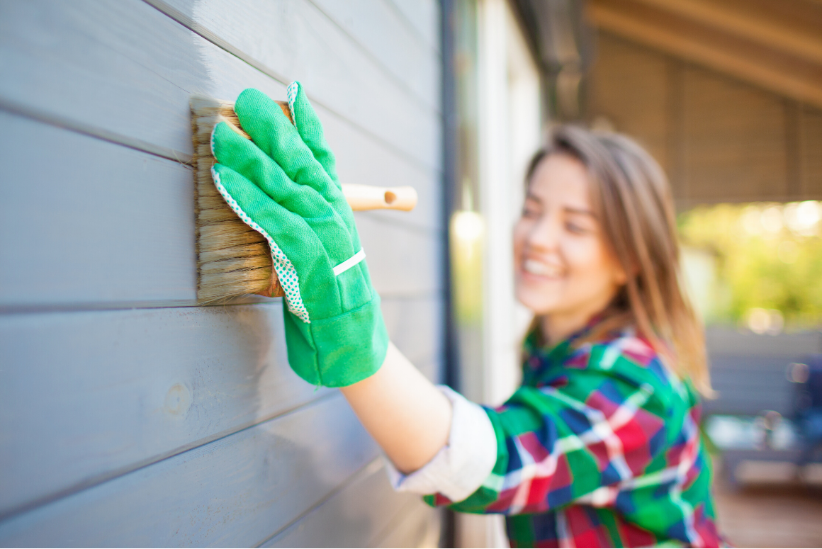 woman washing the siding on her home