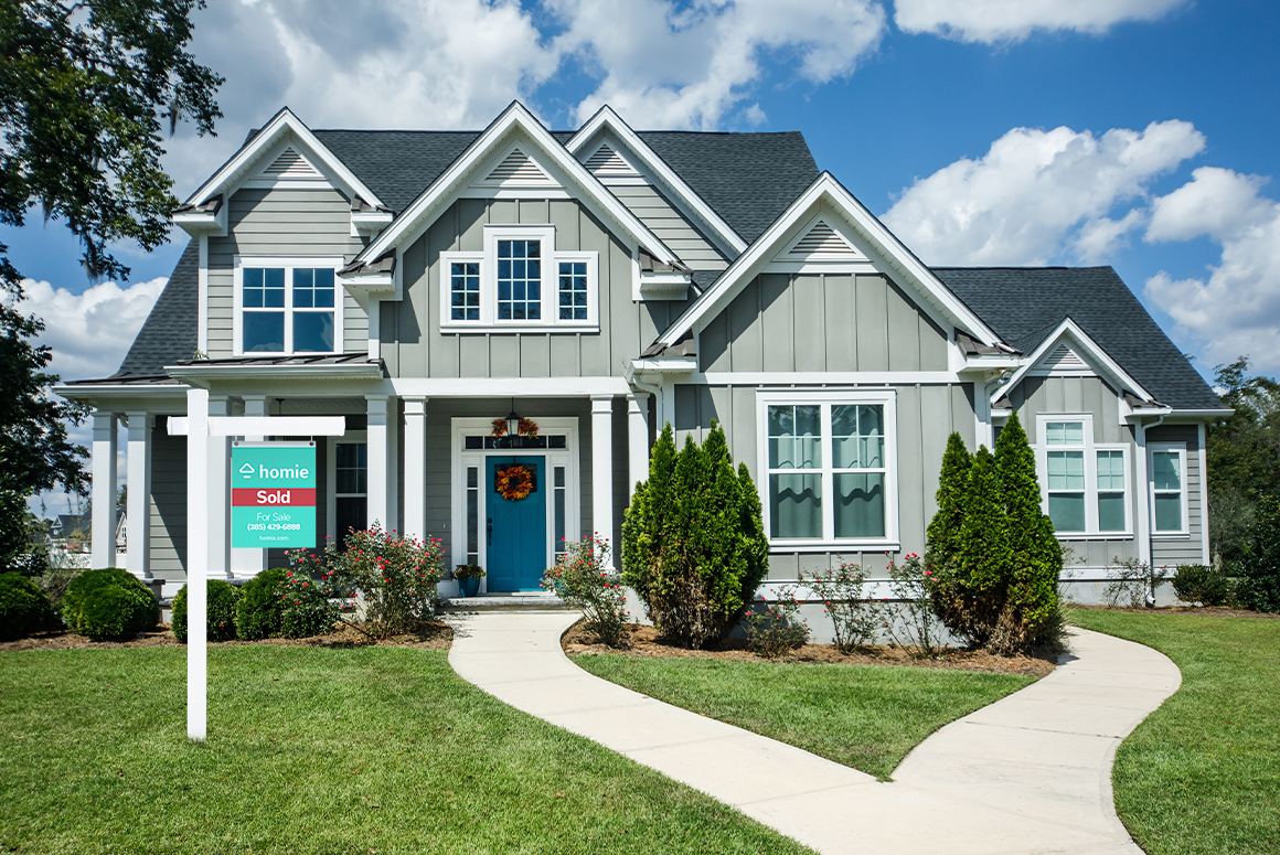 beautiful craftsman home with homie sold sign in the yard