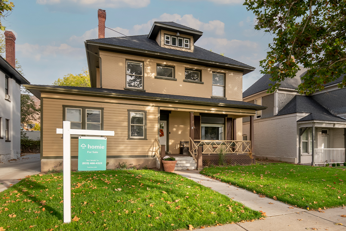 beige house with homie for sale sign