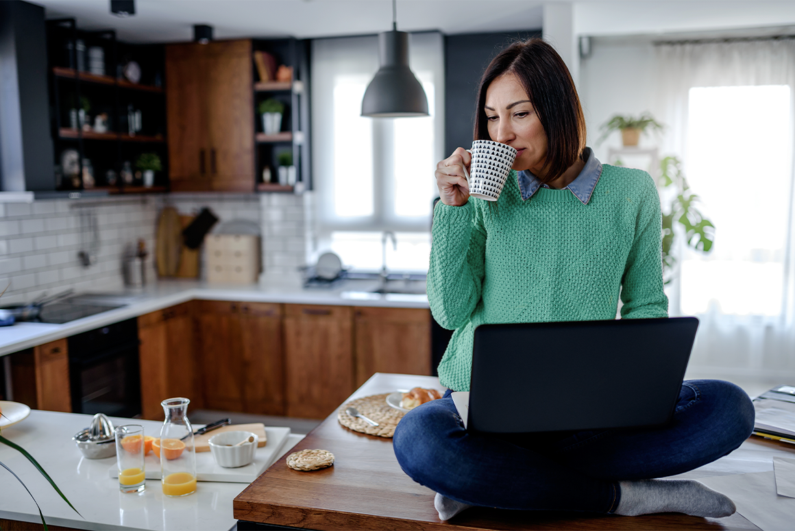 woman sitting on a counter, using a computer