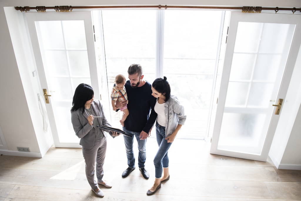 young couple with child in a new home with a showing agent