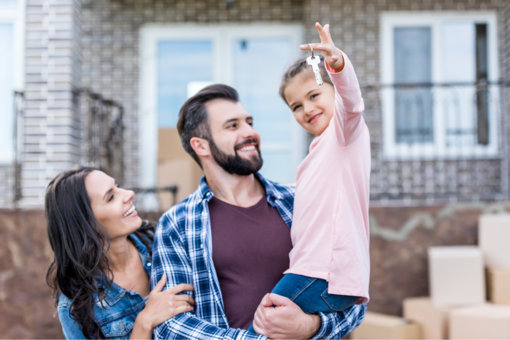 young family with a daughter holding the keys to their new home