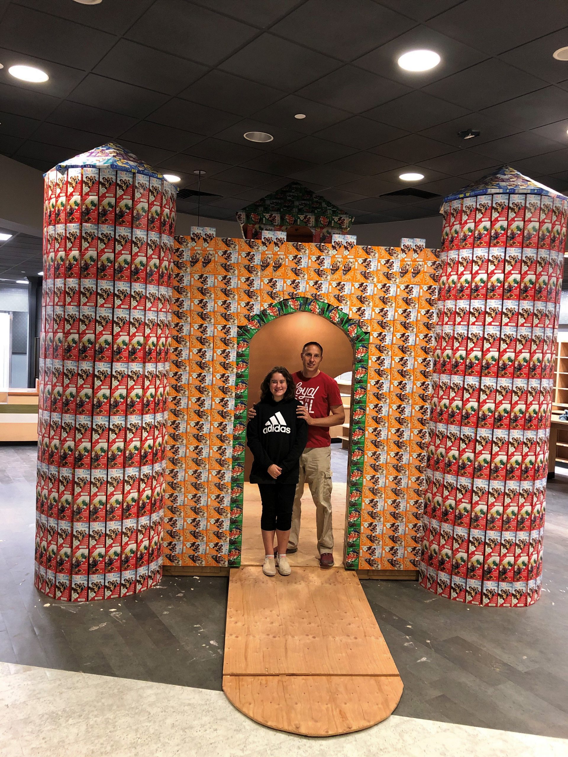 Girl Scout Mija with her father in front of the cookie castle